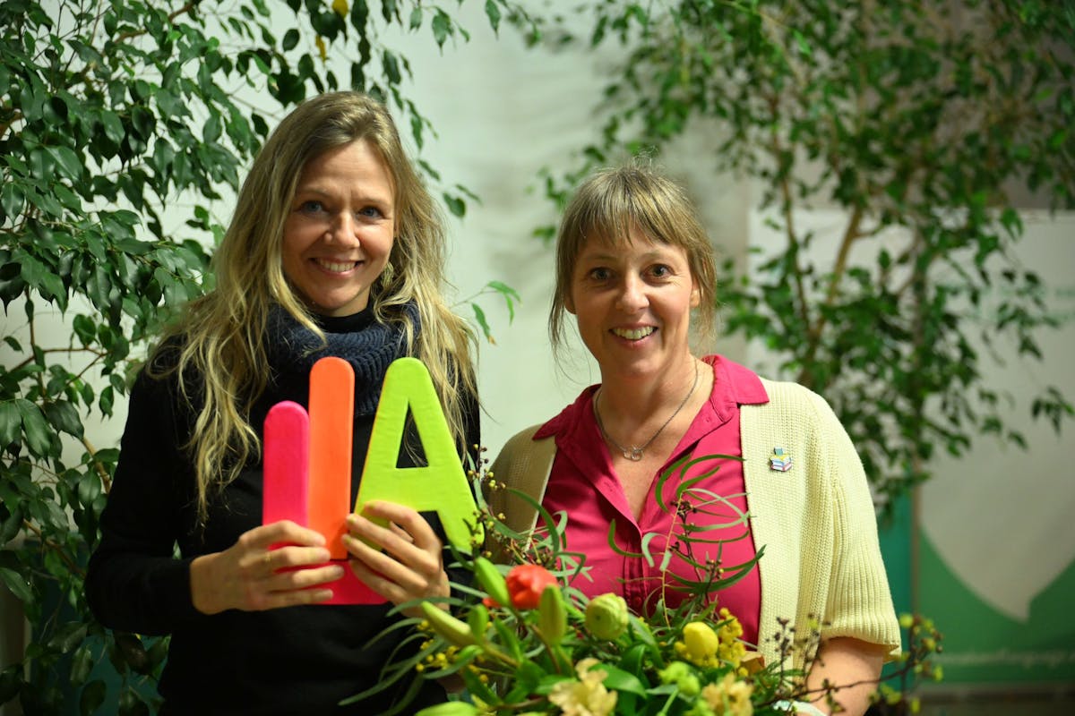 Caroline De Neve, coördinator kinderen- en jongerenwerking Creatief Schrijven vzw, en An Leenders, directeur Creatief Schrijven vzw met LIA in de hand