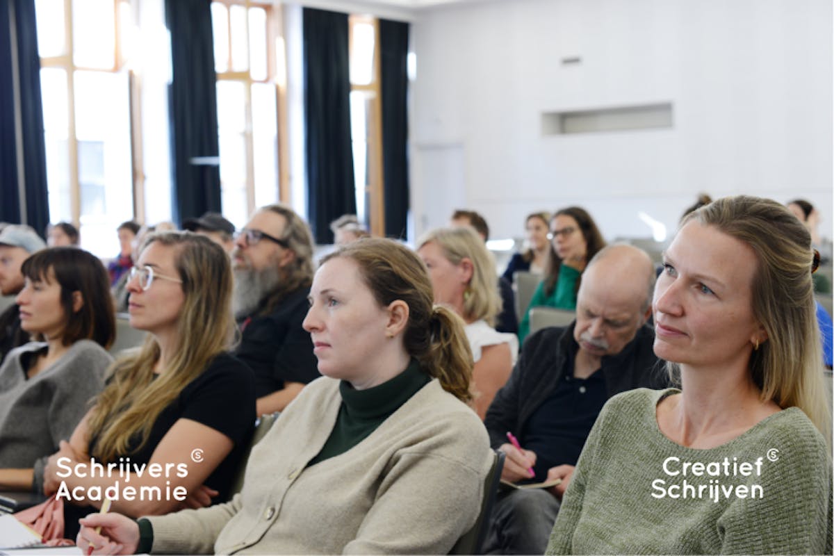student van SchrijversAcademie zitten in aula en luisteren naar uitleg van docent