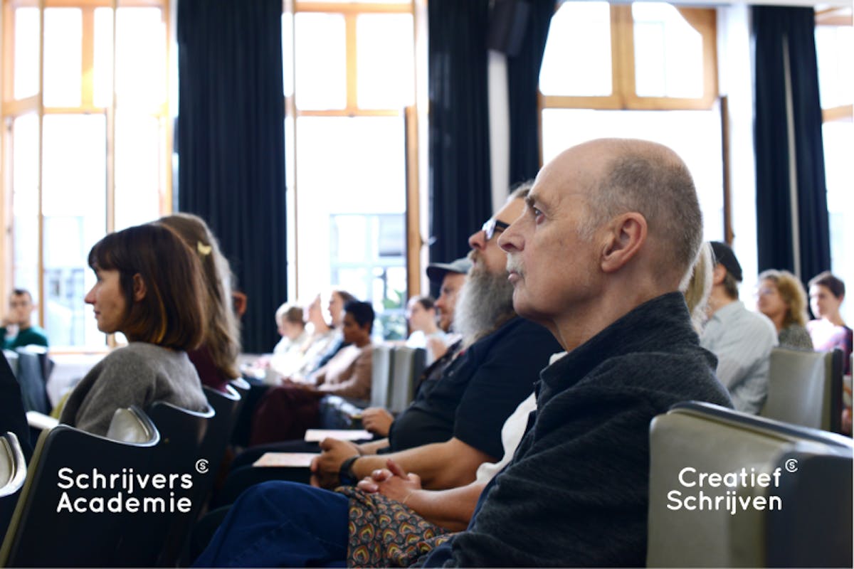 student van SchrijversAcademie zitten in aula en luisteren naar uitleg van docent