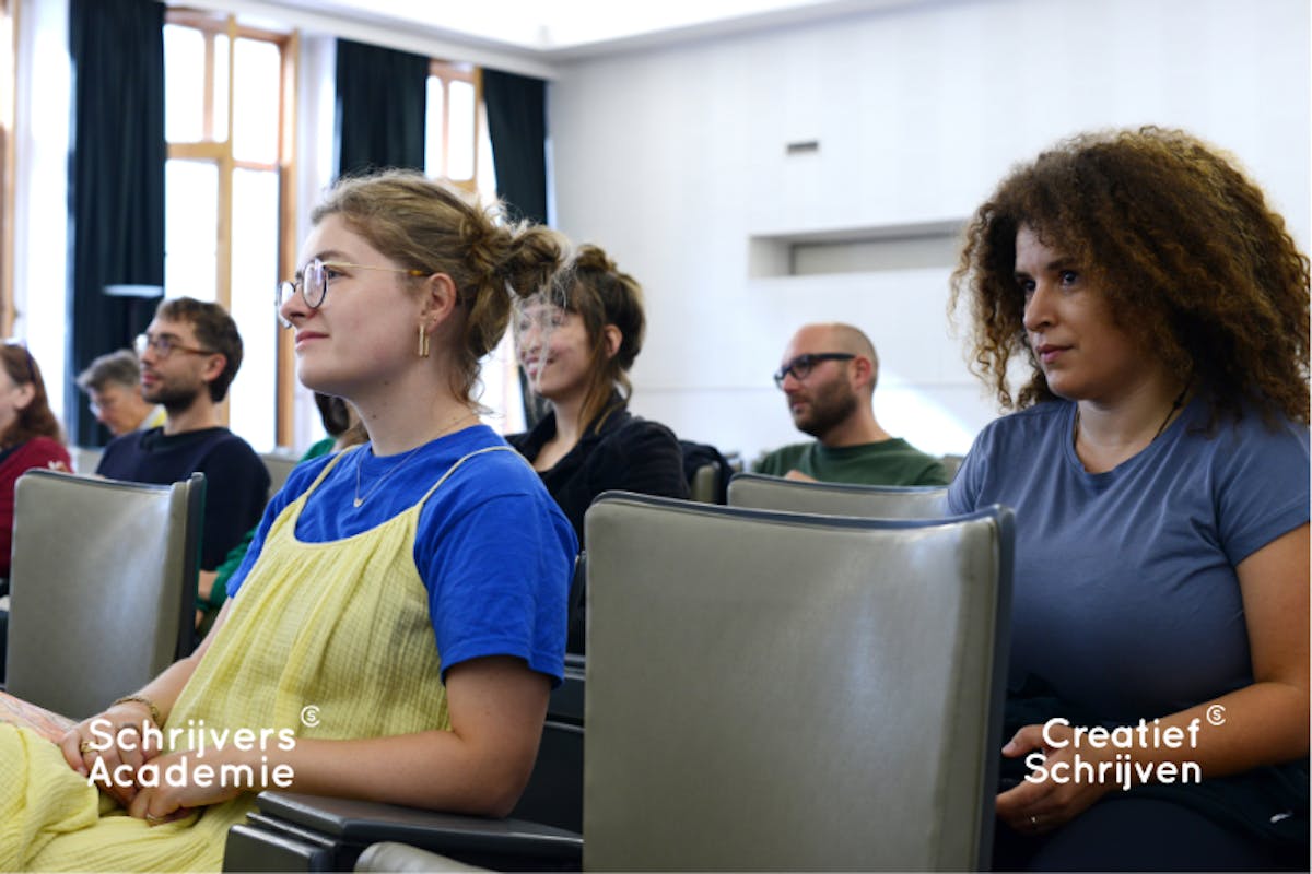 student van SchrijversAcademie zitten in aula en luisteren naar uitleg van docent